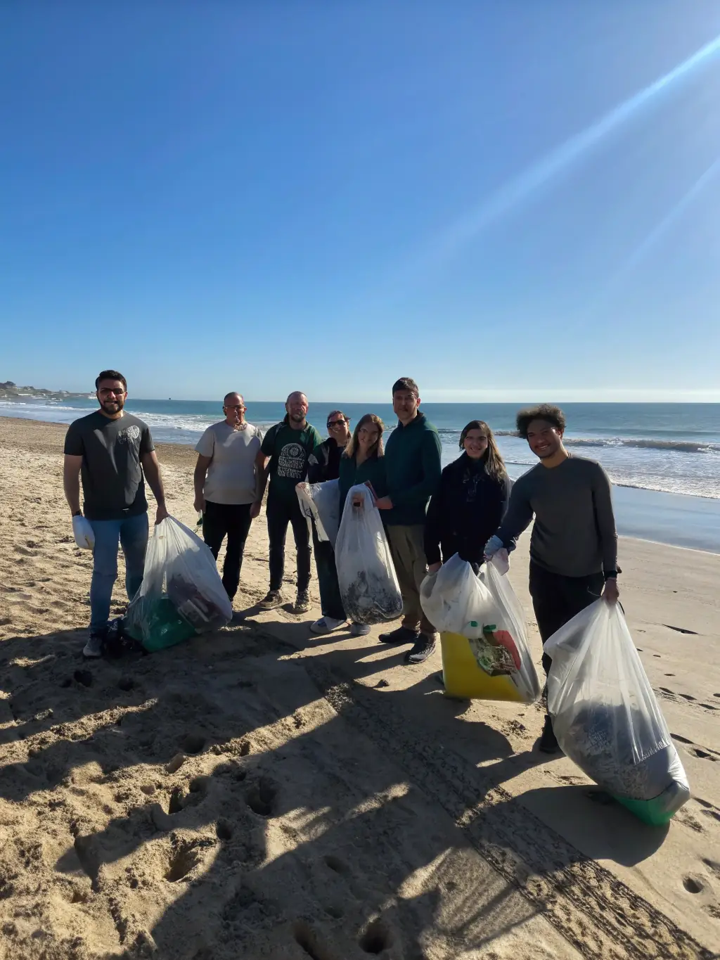 A team participating in a beach clean-up activity during a sustainable beach volleyball tournament organized by 3S: Sustainable Sports Journey, highlighting marine conservation.